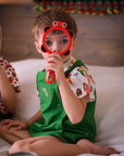 Toddler in a green Hungry Caterpillar romper and food-print shirt