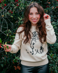 Woman wearing the Adult Paddington Bear Sweater ab ivory cotton knit sweater with classic Peggy Fortnum Paddington Bear illustration
