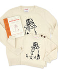 Adult Paddington Bear Sweater in ivory cotton knit, featuring classic Peggy Fortnum illustration. Shown with matching kids' sweater and Paddington book