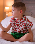 Child wearing a strawberry print short-sleeve button-up shirt and green shorts, part of The Very Hungry Caterpillar collection