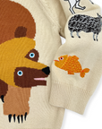 Detailed view of the Brown Bear sweater sleeve with embroidered storybook animals on cozy knit fabric.