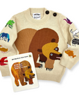 Soft cotton knit sweater with a bear illustration and embroidered animals, displayed with its storybook inspiration