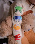 Close-up of a child wearing the Brown Bear sweater, showing colorful embroidered animals on the sleeve, including a frog, horse, duck, and bird