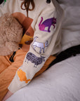 Close-up of a children's knit sweater with colorful embroidered animals on the sleeve