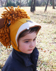 Toddler wearing a cozy wool-blend felt lion hat with curly mane and adjustable chin strap for warmth and play.