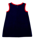 Back view of the Little Goodall Girls Pocket Paddington Bow Dress in dark blue wool with red trim. A-line silhouette, sleeveless, with button closure.
