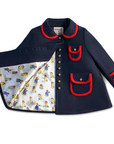 Elegant dark blue winter coat with red trim, gold buttons, and a charming illustrated satin lining. Warm wool-blend fabric
