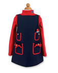 Girls' wool pocket dress with red trim, gold-tone buttons, bow details. Features four pockets and a removable embroidered bear for play. Heirloom quality