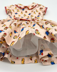 Pink girls' dress with a full twirl-ready skirt, red trim, and soft cotton lining for comfort and volume—perfect for special occasions
