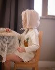 toddler wearing Little Goodall embroidered linen bunny jacket, side view showing bunny and carrot basket design