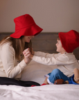 Mother and child wearing matching red wool bucket hats