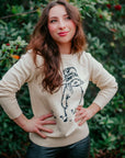 Woman wearing the Adult Paddington Bear Sweater, an ivory cotton knit unisex sweater featuring classic Peggy Fortnum’s Paddington Bear illustration