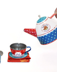 Paddington Tin Tea Set with teapot pouring water into a red polka-dot cup, featuring classic Paddington Bear design and accessories.