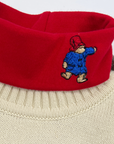 Little Goodall organic cotton red turtleneck for kids featuring an embroidered Paddington Bear on the collar. Soft, cozy, sensory-friendly, and perfect for layering