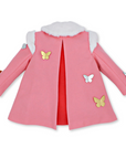 Back view of pink wool girls' coat featuring a hot pink pleat, faux fur collar, and gold and silver butterfly appliqués on the sleeves and bodice