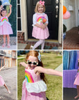 Children posing in pink rainbow sundresses at a celebration
