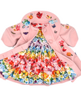Rainbow Bloom dress with vibrant florals, paired with a pink wool coat embroidered with butterflies and flowers, laid flat to highlight the full design