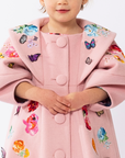 Close-up of pink wool girls' coat with embroidered flowers, butterfly appliqués, and lantern sleeves. Elegant and perfect for special occasions