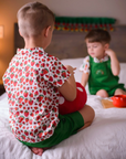 Child seen from the back wearing a strawberry print button-up shirt from The Very Hungry Caterpillar collection, paired with green shorts