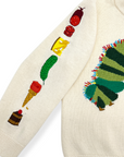 Close-up of cream knit sweater sleeve with embroidered foods from The Very Hungry Caterpillar story, including cheese, pickle, and ice cream