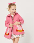 Model wearing pink dog coat, exposing four buttons down the front.