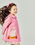 Model wearing Pink dress coat with dog on side