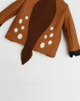 Back of fawn coat displaying white spots around a brown stripe in the middle of the back. 