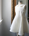 Ivory linen party dress displayed on a mannequin, featuring a Peter Pan collar, empire waist, and flowing princess-seamed skirt