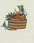 Close-up of hand-embroidered design on linen fabric featuring a brown bunny in a woven basket