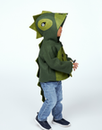 Child wearing Little Goodall Cheeky Green Dinosaur Coat with ridged hood, plush lining, clawed sleeves, and a long tail, made from soft wool felt