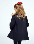 Elegant navy wool coat for girls by Little Goodall, showcasing the back pleat and refined tailoring