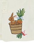 Close-up of embroidered bunny in a bushel basket with carrots and radishes on Little Goodall linen jacket. Fine heirloom-quality stitching detail.