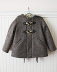 Front view of the Little Goodall Flopsy Bunny coat, featuring cozy wool fabric, toggle closures, hidden buttons, and functional welt pockets