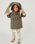 Smiling toddler wearing a wool Flopsy Bunny Coat with floppy ears, toggled front, and a cozy hood, playfully lifting the bunny ears