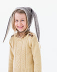 Child wearing a mushroom brown Flopsy Bunny Hat with floppy gray ears, wool blend felt, soft fleece lining, and a chin strap