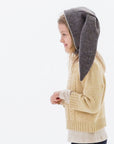 Side angle view of a child in the mushroom brown Flopsy Bunny Hat with gray floppy ears, wool felt, and a velcro chin strap