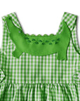 Close-up of green gingham sundress featuring an embroidered alligator applique on the bodice