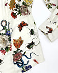 Close-up of Little Goodall ivory botanical print shirt, showing sleeve cuff and floral details