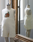 Front and back view of ivory linen romper with embroidered bunny and vegetable basket. Childsware for boys and girls