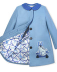 Ladies Aldrich and Madame De Bleu Coat in merino wool, featuring a satin lattice-print lining with blue dog illustrations and detailed embroidery