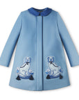 Ladies Aldrich and Madame De Bleu Coat in soft blue merino wool, featuring elegant hidden buttons and embroidered dog motifs with tassel accents