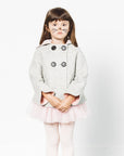 Girl wears a grey bunny coat with pink-lined cuffs, a cozy hood, and double-breasted buttons, styled with a pink tutu and tights.