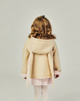 Back view of the tan bunny coat on the model, displaying floppy bunny ears with the hood down.