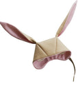 Light tan bunny hat with pink lining within the ears and rim of hood. White hat lining peaking through from inside the hat.