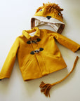 Flat lay of golden wool Luxe Lion Coat with detachable lion hood, soft mane, ears, rope toggle closures, claw-detailed cuffs, and matching tail.