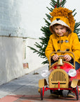 A child in a warm gold wool lion coat rides a festive red toy car, featuring toggle closures and a playful hood