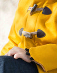 Close-up of Little Goodall Luxe Lion Coat featuring rope and toggle closures with faux leather details. Cuff styled with soft black claw accents