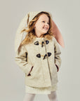 Toddler girl wearing a Merino wool Snowshoe Rabbit Coat with floppy bunny ears and toggle closures