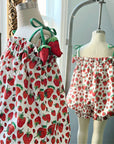 Front and back mannequin display of a strawberry-print bubble romper with adjustable straps