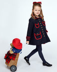 Luxurious navy wool coat for girls featuring red accents and gold buttons. A stylish and warm winter outfit.